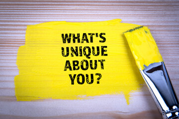 What's Unique About You. Yellow paint and paint brush on wooden texture background