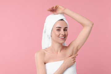Beautiful woman showing armpit with smooth clean skin on pink background