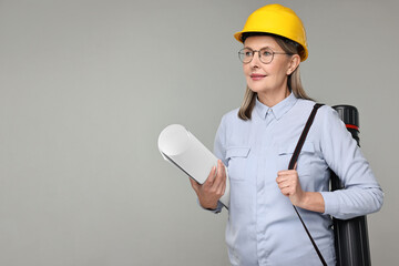 Architect in hard hat with draft and tube on grey background, space for text