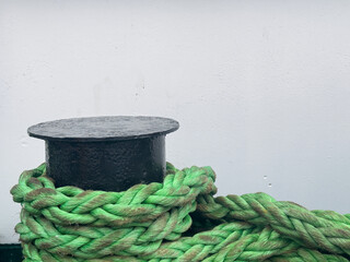 Fototapeta na wymiar rope on a dock , maritime transportation concept, green plastic rope for tying the ship to the pier, abstract background