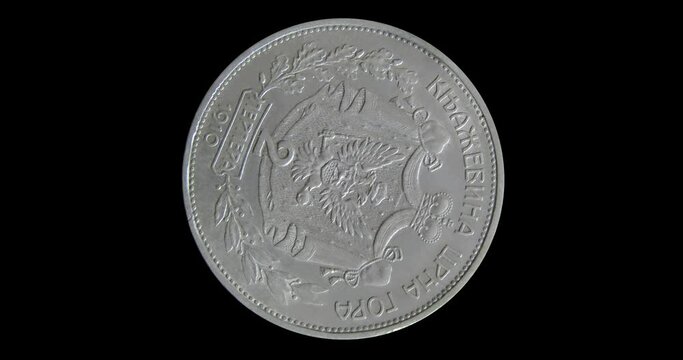 Reverse of Montenegro coin 2 perpera, 1910 with inscriptions meaning PRINCIPALITY OF MONTENEGRO and TWO PERPERS. Seamless animation in 4k video