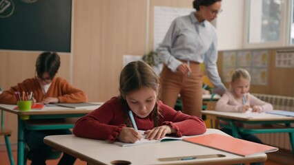 Female teacher woman tutor at school class lesson teach children walking classroom elementary primary education learning kids boys girls teaching diversity schoolchildren help with study check tasks