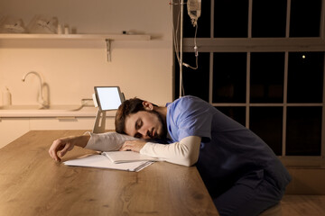 Obraz premium Male nurse sleeping at table in clinic