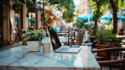 Outdoor Cafe Setting With Laptop and Smartphone on Table Daytime