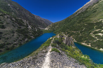 Fototapeta na wymiar Lake with blue clear clear water in the mountains in summer. Koksai Ainakol Lake in Tien Shan Mountains in Asia in Kazakhstan