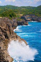 Cinematic aerial landscape shots of the beautiful island of Nusa Penida. Huge cliffs by the shoreline and hidden dream beaches with clear water and foaming wave.
