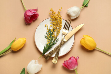 Beautiful table setting with mimosa flowers and tulips on brown background