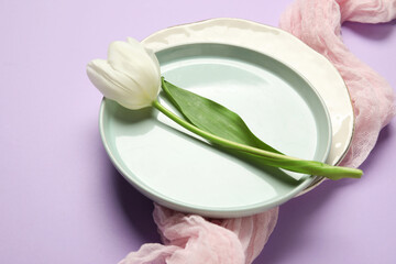 Beautiful table setting with white tulip on lilac background
