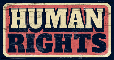 Aged and worn human rights sign on wood