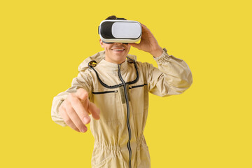 Male beekeeper in VR glasses pointing at viewer on yellow background