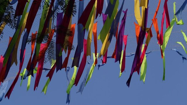 Decorations made of colorful cloth of different colors are flying in the wind on the ceiling.