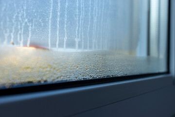 Indoor close-up of a leaky window. Condensate water on window