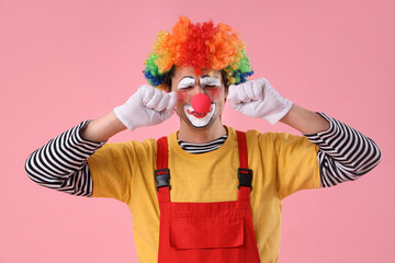 Portrait of sad clown on pink background. April Fool's day celebration