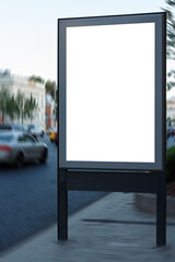 Vertical billboard near the road in the city. Close-up. Cars drive in the background. Mock-up.