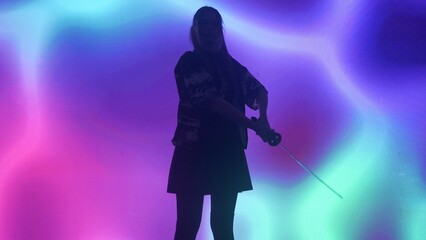 Person against big digital wall in studio. Woman silhouette with japanese sword katana acts in...