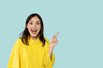 Happy Young Woman Pointing Aside At Copy Space on Blue Background 