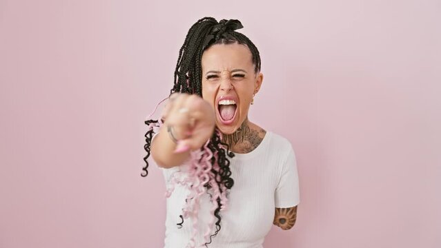 Furious hispanic amputee woman, standing against a pink isolated background, pointing angrily at you, the camera. looking frustrated, displeased, and majorly upset over...