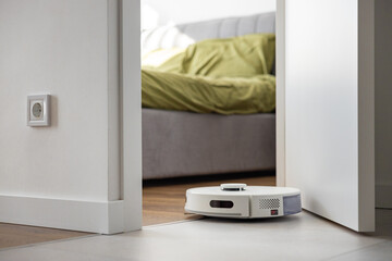 A smart robot vacuum cleaner enters the bedroom through the threshold without obstacles. Dry and...