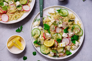 Fresh vegetable salad with couscous and feta in ceramic bowl. selective focus
