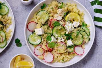 Fresh vegetable salad with couscous and feta in ceramic bowl. selective focus