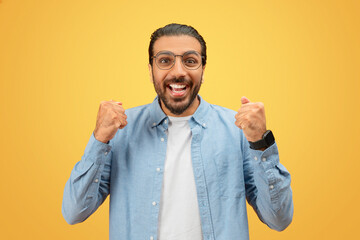 Excited man in glasses with clenched fists