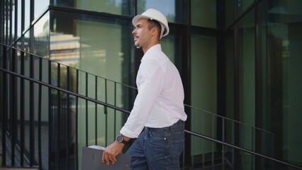 Successful architect walking city holding folder closeup. Man in hardhat working