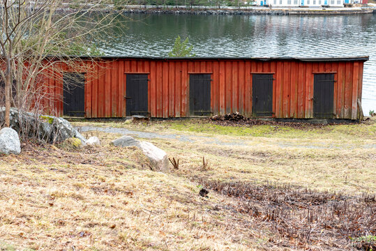 old red wooden storage building with brown doors, sweden