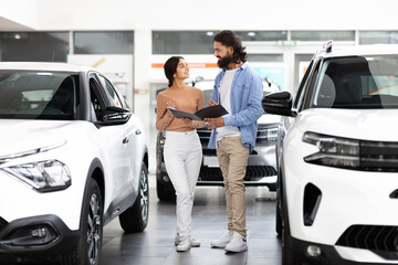 Couple considering a car in dealership