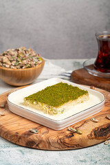 Kadayif dessert with pistachio and milk. Cold kadayif with chocolate on a wooden serving board. Famous dishes of Turkish cuisine