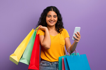 Fototapeta na wymiar Happy shopper with colorful bags and phone