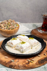 Baklava with white chocolate and milk. Cold baklava with chocolate on a wooden serving board. Famous dishes of Turkish cuisine