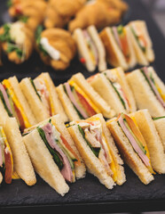 Catering table, beautifully decorated banquet table with variety of different food snacks, sandwiches, croissants and appetizers on party event or celebration, delicatessen setting, coffee break
