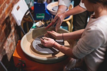 Pottery lesson master class for kids children, process of making clay pot on pottery wheel, potter...