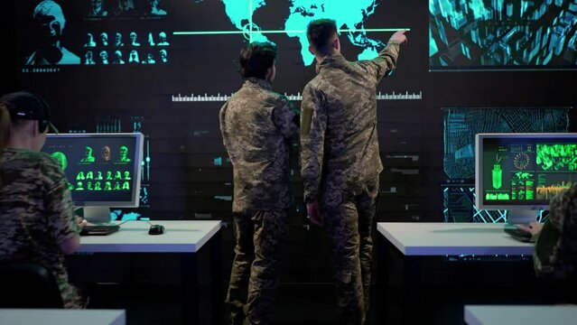 Group of security squad in control center. Military headquarters surveillance officers cyber police working in office, discussing information on laptop.