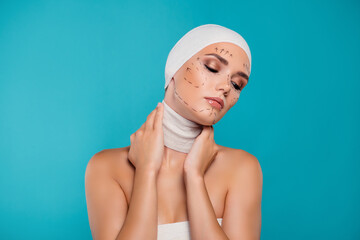 Photo of plastic surgery patient lady touch neck wrapped in medical bandage isolated over cyan background