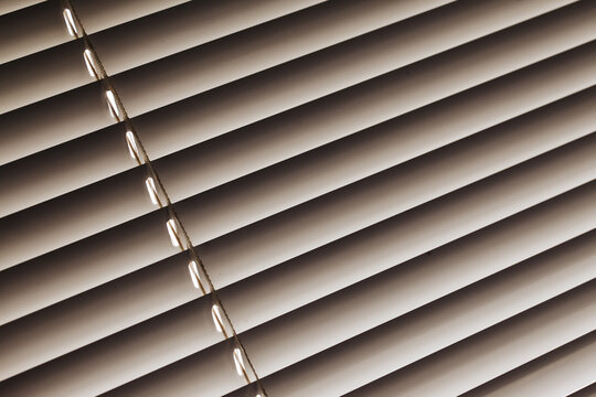 Window blinds texture. Closeup jalousie pattern. Parallel lines background. Diagonal line. Sunlight protection. Home interior window.