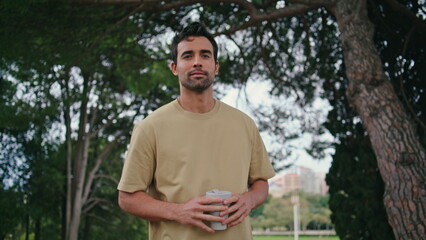 Calm businessman walking coffee enjoying weekend morning close up. Man strolling