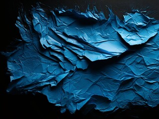 torn blue papper on a black background 