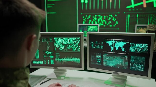 Person security squad in control center. Military headquarters surveillance officer cyber police working in office, tracking and managing security, back shot.