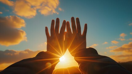Image of hands raised up towards the sun.