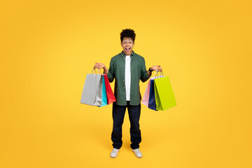 Young man with shopping bags excited