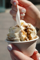 Eis creme essen gehen mit Löffel im Becher in der Sonne