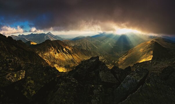The rays of the setting sun that break through the peaks and clouds, Tatra National Park, Poland, Europe