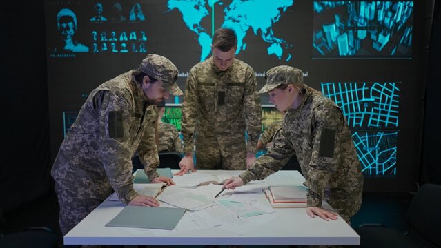 Group of security squad in control center. Military headquarters surveillance officers cyber police briefing at the table in office, checking paper documents.
