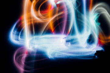 Abstract colorful irregular lines on black background and wall texture. Long exposure. Light painting photography.