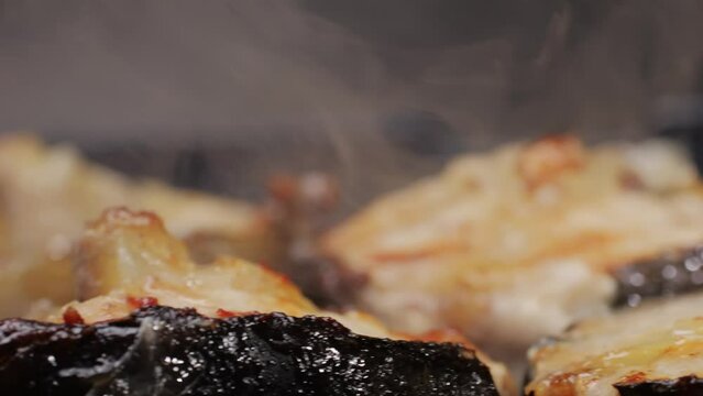 Cooking fillet sturgeon beluga white fat fish on grill or frying pan with oil close-up. Roast healthy food concept. Fry sturgeon, hake, cod fish steak pieces fillet. Healthy diet