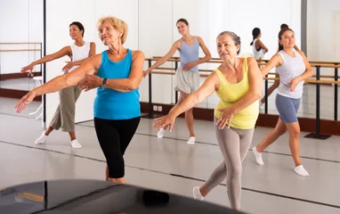 Gordijnen Group of various aged women dancing modern dance in studio. © JackF