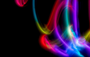 Abstract colorful irregular lines on black background and wall texture. Long exposure. Light painting photography.