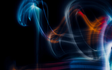 Obraz premium Abstract colorful irregular lines on black background and wall texture. Long exposure. Light painting photography.