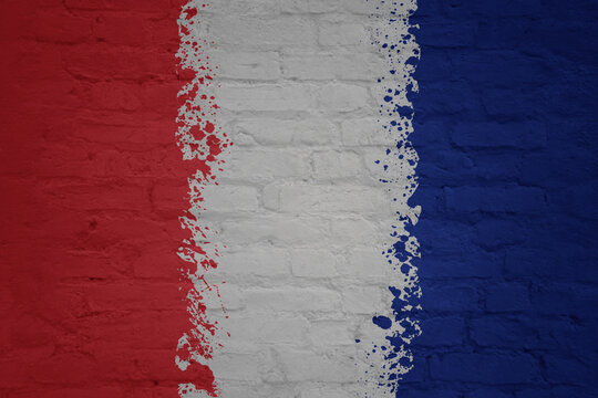 colorful painted big national flag of france on a massive brick wall
